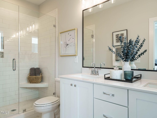 bathroom with vanity, toilet, and a shower with door