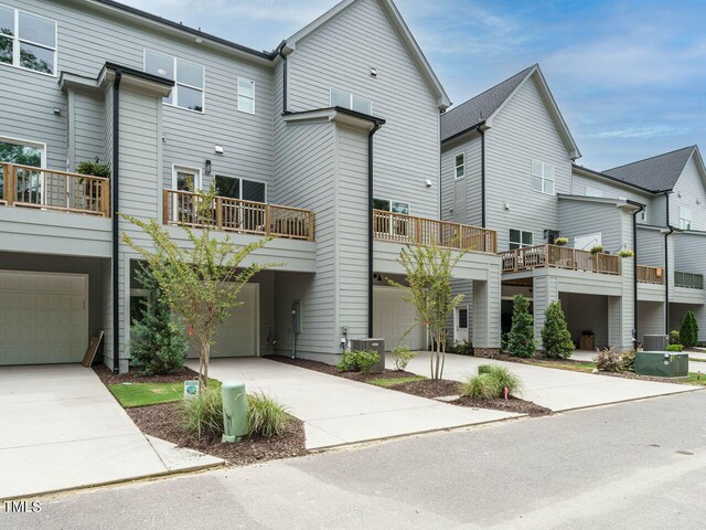 view of front facade featuring a garage, a balcony, and central AC