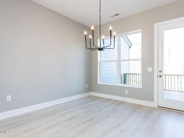 unfurnished dining area featuring light hardwood / wood-style floors and a notable chandelier