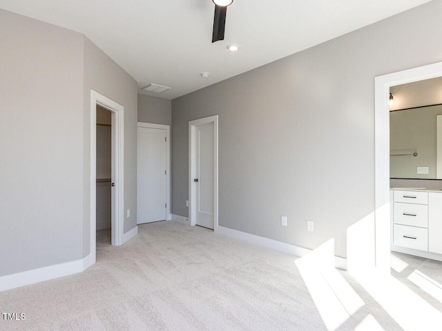 unfurnished bedroom with light colored carpet, ceiling fan, and ensuite bath