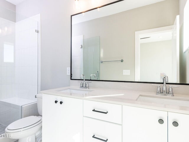 bathroom with vanity, toilet, and a shower with door