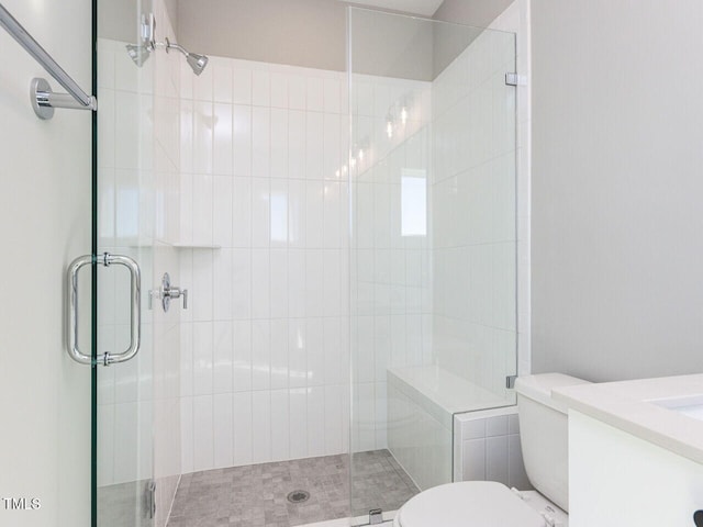 bathroom featuring vanity, toilet, and a shower with shower door