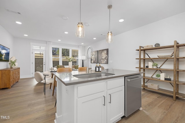 kitchen with white cabinets, dishwasher, hanging light fixtures, a kitchen island with sink, and a sink