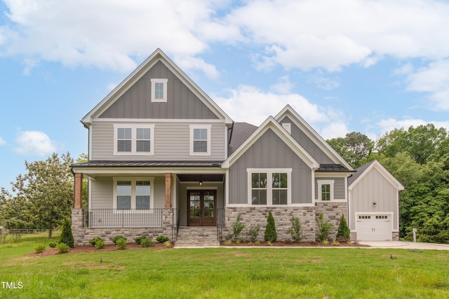 craftsman-style house featuring french doors, a front lawn, covered porch, a garage, and an outbuilding