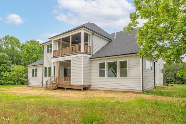 back of house featuring a lawn, ceiling fan, and a balcony