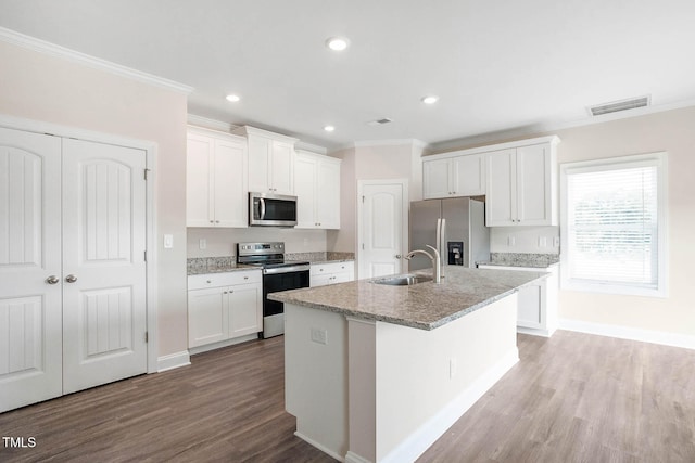 kitchen with hardwood / wood-style flooring, white cabinetry, a kitchen island with sink, and appliances with stainless steel finishes