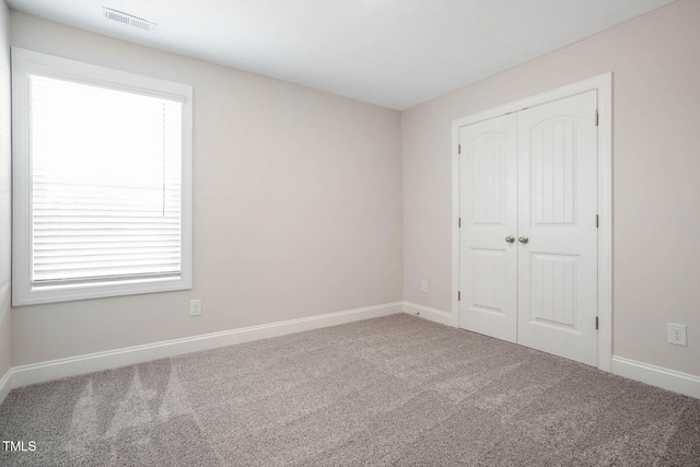 unfurnished bedroom featuring carpet floors and a closet