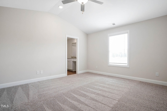 unfurnished bedroom featuring carpet flooring, ensuite bathroom, ceiling fan, and lofted ceiling