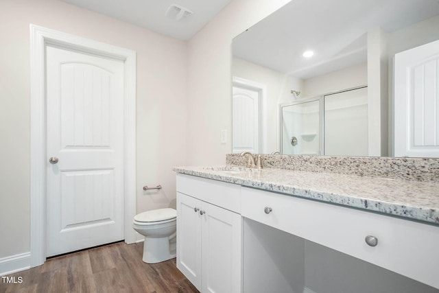 bathroom featuring hardwood / wood-style floors, vanity, toilet, and walk in shower