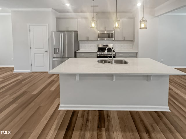 kitchen with a large island, decorative light fixtures, and appliances with stainless steel finishes