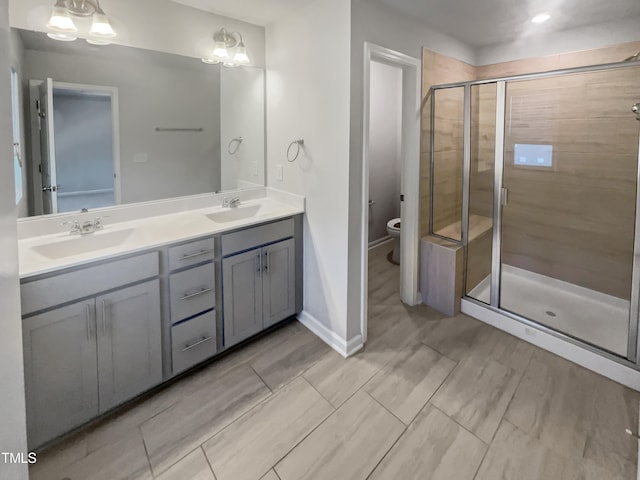 bathroom featuring toilet, vanity, a chandelier, and walk in shower