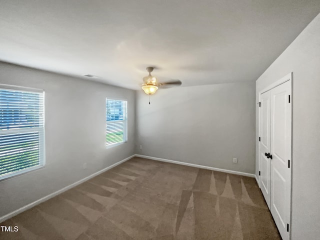 empty room with carpet flooring and ceiling fan