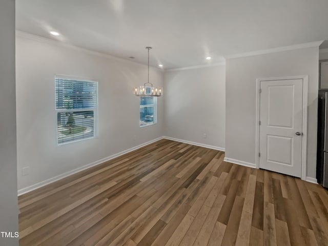 unfurnished dining area featuring hardwood / wood-style flooring, ornamental molding, and a chandelier