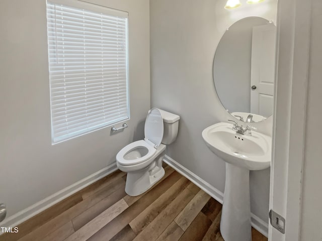 bathroom featuring toilet and wood-type flooring