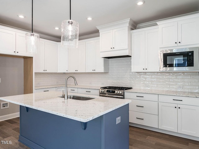 1713 Grassy Falls Ln, Wendell, NC 27591 - kitchen featuring appliances with stainless steel finishes, a breakfast bar, white cabinetry, dark wood finished floors, and an island with sink