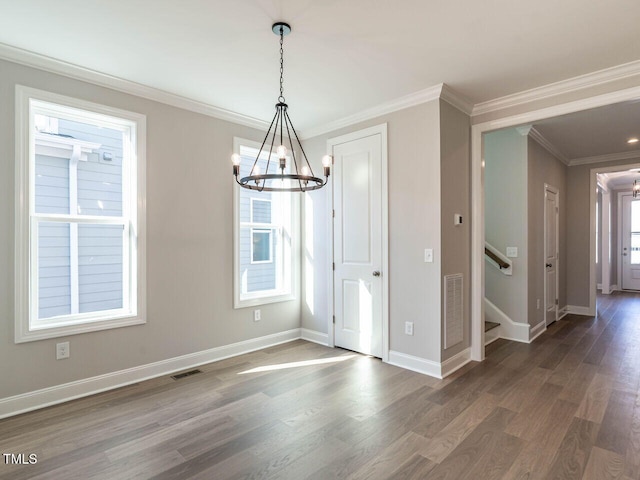 unfurnished dining area featuring dark wood-type flooring, crown molding, a wealth of natural light, and a notable chandelier