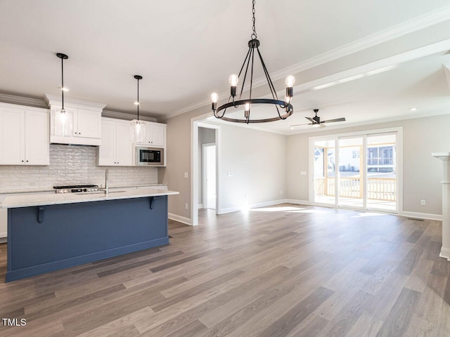1713 Grassy Falls Ln, Wendell, NC 27591 - kitchen with black microwave, a chandelier, a ceiling fan, decorative backsplash, and wood finished floors