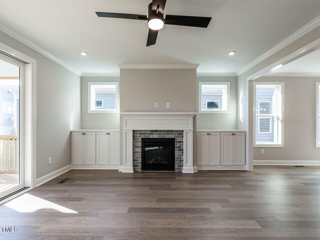 1713 Grassy Falls Ln, Wendell, NC 27591 - unfurnished living room featuring wood finished floors, ornamental molding, a ceiling fan, recessed lighting, and a glass covered fireplace