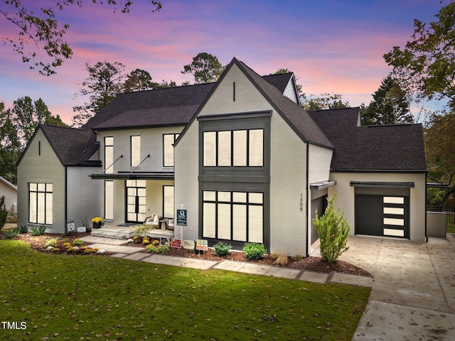 view of front of house with a lawn, a garage, and covered porch