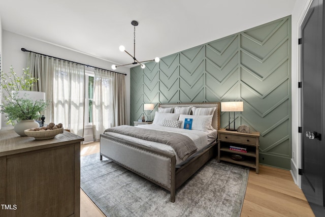 bedroom with light hardwood / wood-style floors and a chandelier