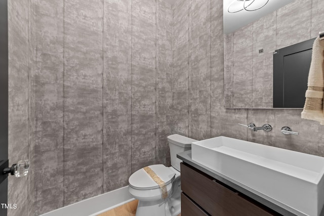 bathroom with hardwood / wood-style floors, vanity, and toilet