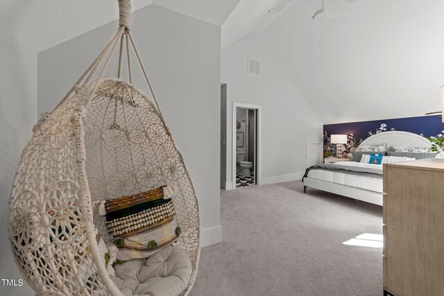 bedroom featuring lofted ceiling, ensuite bathroom, and carpet