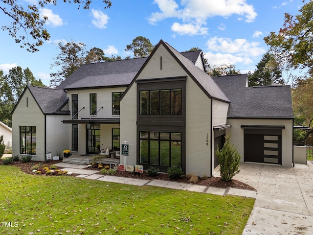 rear view of property featuring a lawn, covered porch, and a garage