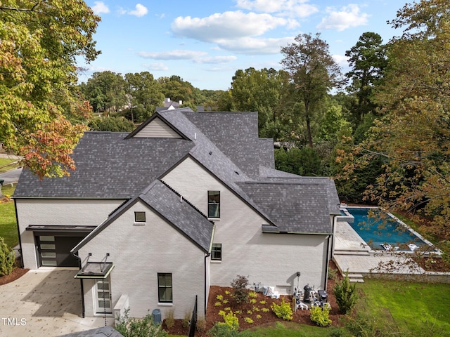 back of property with a garage and a patio area