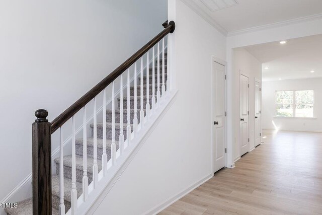 stairs featuring hardwood / wood-style floors and crown molding