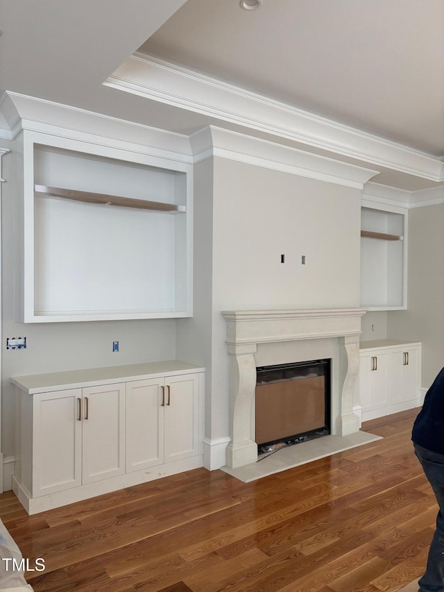 8305 Society Pl, Raleigh, NC 27615 - unfurnished living room with ornamental molding, a fireplace with flush hearth, and wood finished floors