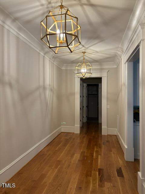 8305 Society Pl, Raleigh, NC 27615 - unfurnished dining area featuring a chandelier, crown molding, and wood finished floors