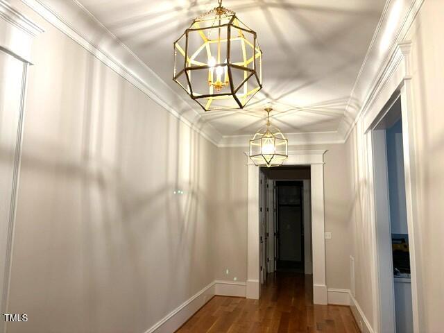 8305 Society Pl, Raleigh, NC 27615 - hall featuring a chandelier, wood finished floors, and crown molding