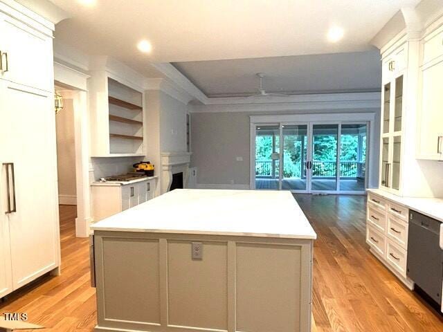 8305 Society Pl, Raleigh, NC 27615 - kitchen featuring light wood-style floors, a kitchen island, dishwasher, light countertops, and white cabinets