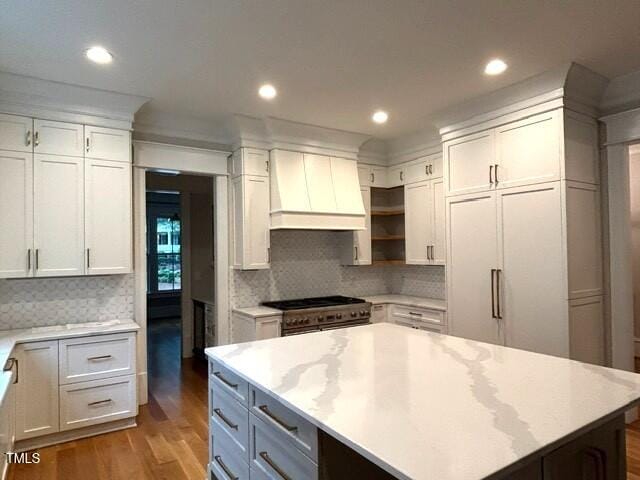 8305 Society Pl, Raleigh, NC 27615 - kitchen with premium range hood, stainless steel range, wood finished floors, white cabinets, and decorative backsplash