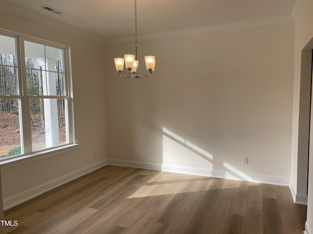 empty room with wood-type flooring, crown molding, and a chandelier