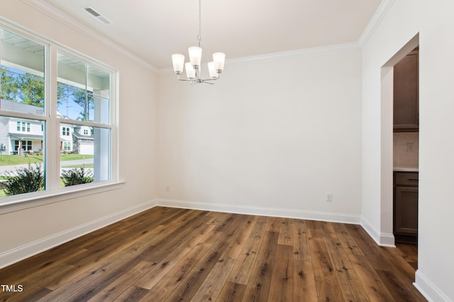 empty room with baseboards, ornamental molding, dark wood finished floors, and a notable chandelier