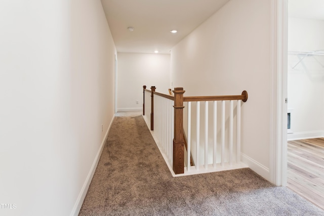 hall with recessed lighting, carpet, baseboards, and an upstairs landing