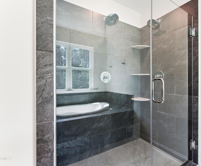 bathroom featuring a stall shower and a tub