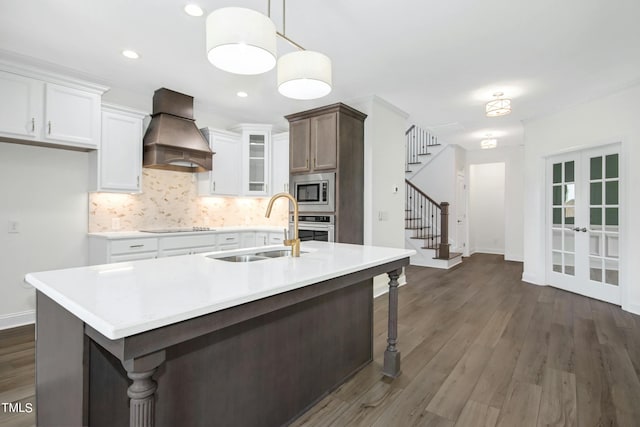 kitchen with french doors, sink, dark hardwood / wood-style floors, custom range hood, and stainless steel appliances