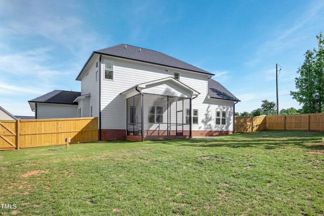 rear view of property featuring a lawn and a sunroom