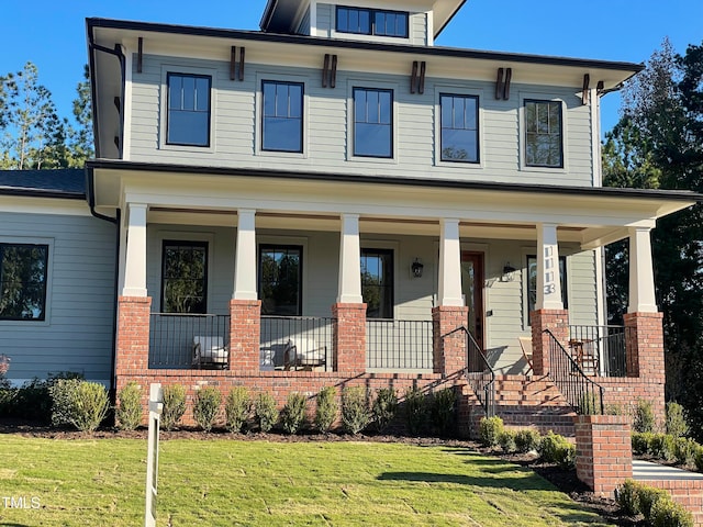 view of front of house with a porch and a front lawn