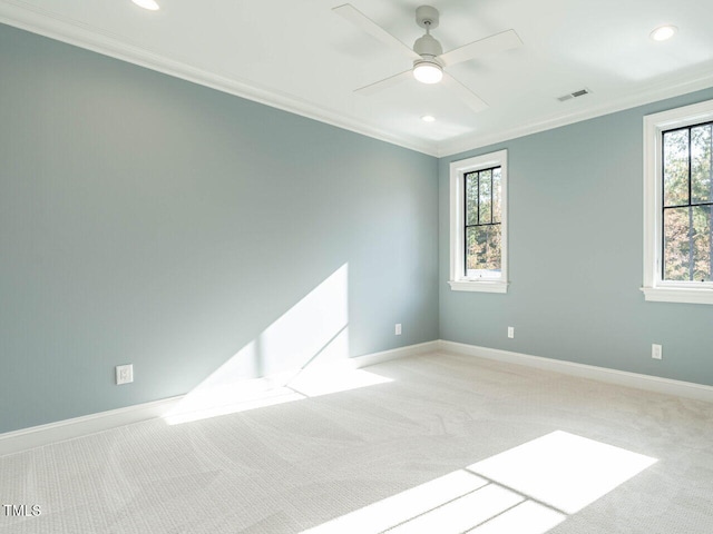 carpeted spare room featuring crown molding and ceiling fan