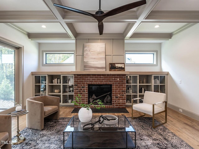 living room with hardwood / wood-style floors, a healthy amount of sunlight, coffered ceiling, and a fireplace