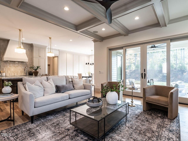 living room featuring ornamental molding, dark hardwood / wood-style floors, a healthy amount of sunlight, and coffered ceiling