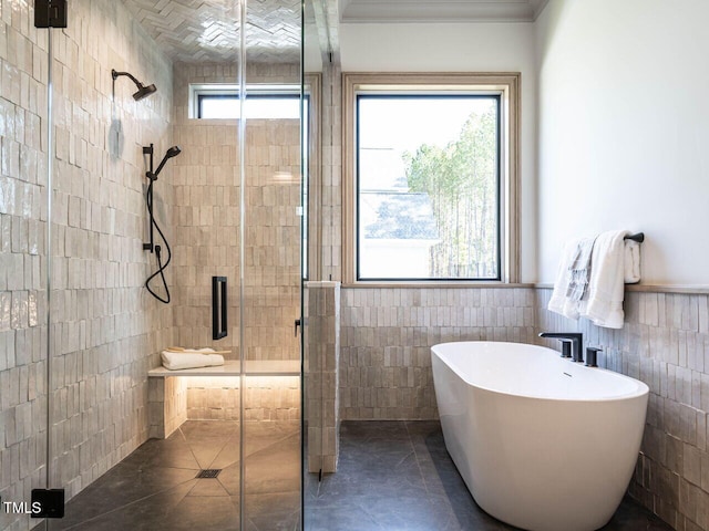 bathroom featuring a healthy amount of sunlight, independent shower and bath, and tile walls