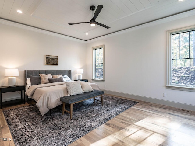 bedroom with ceiling fan, ornamental molding, light hardwood / wood-style flooring, and wood ceiling