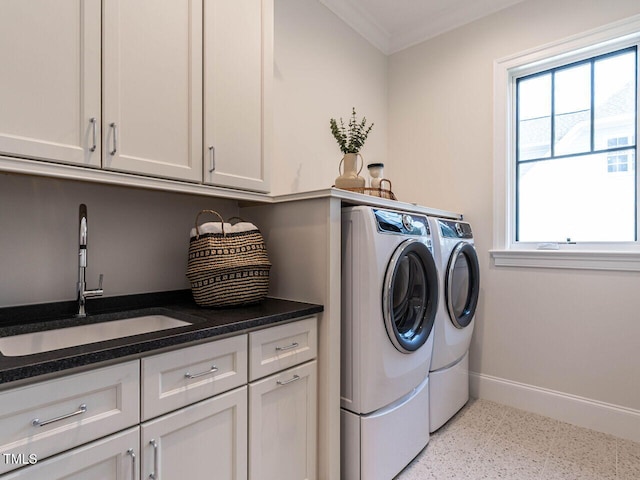 washroom with cabinets, ornamental molding, sink, and washing machine and clothes dryer