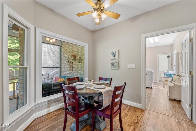 dining space with baseboards, light wood finished floors, and ceiling fan