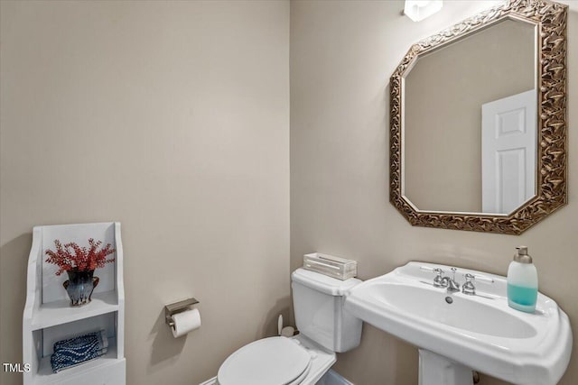 half bathroom with toilet and a sink