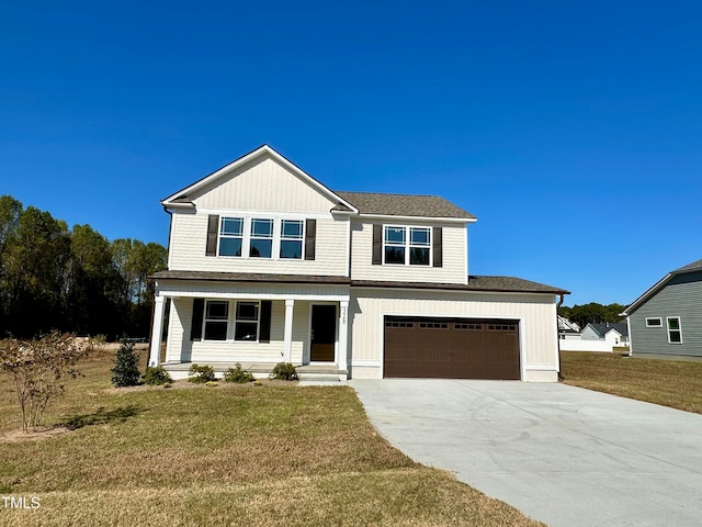 view of front of property featuring a garage, a front lawn, and a porch